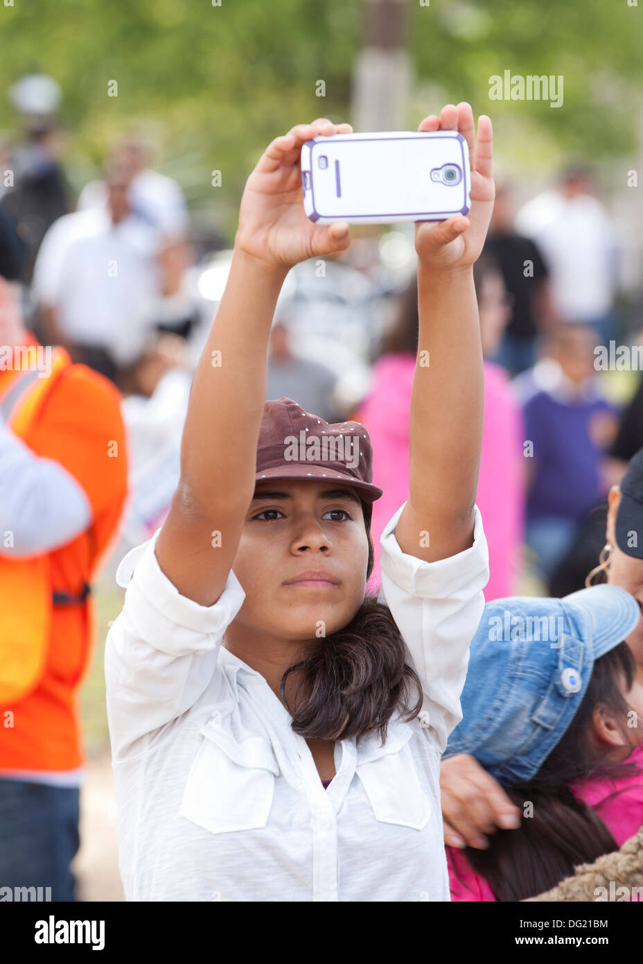Junge weibliche Video taping mit Smartphone an ein outdoor-Event - USA Stockfoto