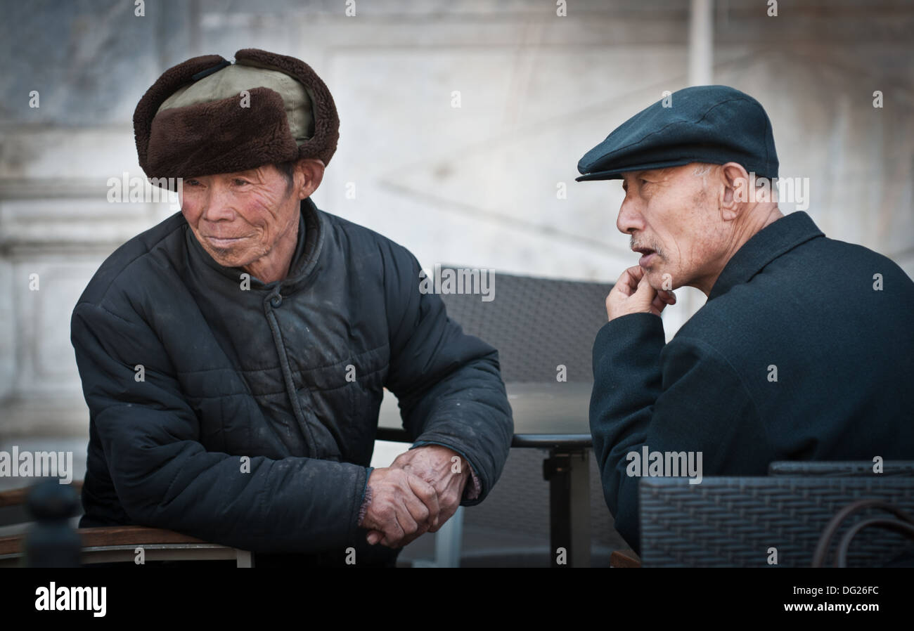 Zwei alte chinesische Männer sitzen im Restaurant in Peking, China Stockfoto