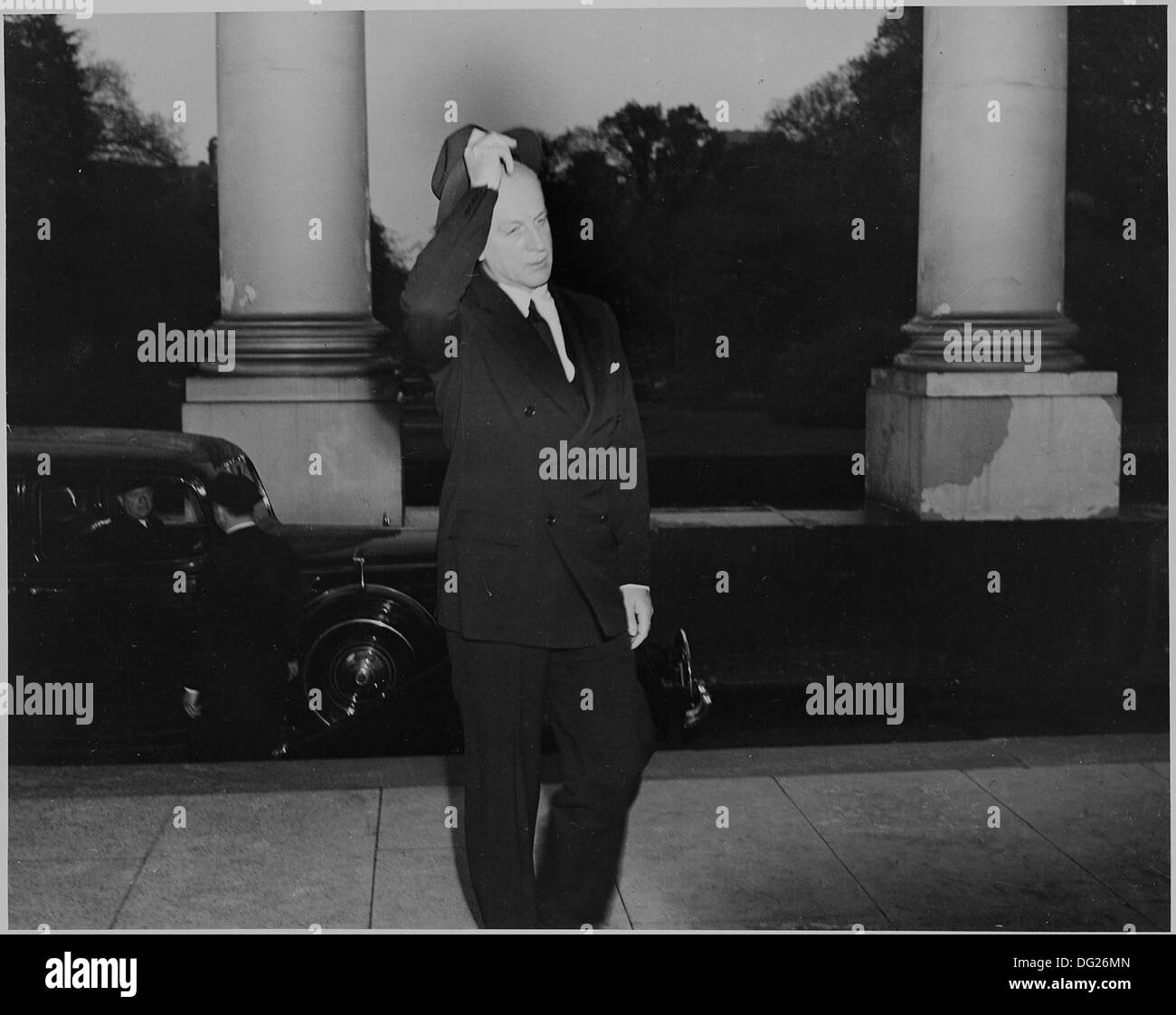 Während der Beerdigung von Präsident Franklin D. Roosevelt wird ein nicht identifizierter Mann beim Betreten des Weißen Hauses gezeigt. Das Ereignis ist ein bedeutender Moment in der Geschichte der USA, da Roosevelts Tod das Ende einer Ära während des Zweiten Weltkriegs bedeutete Stockfoto