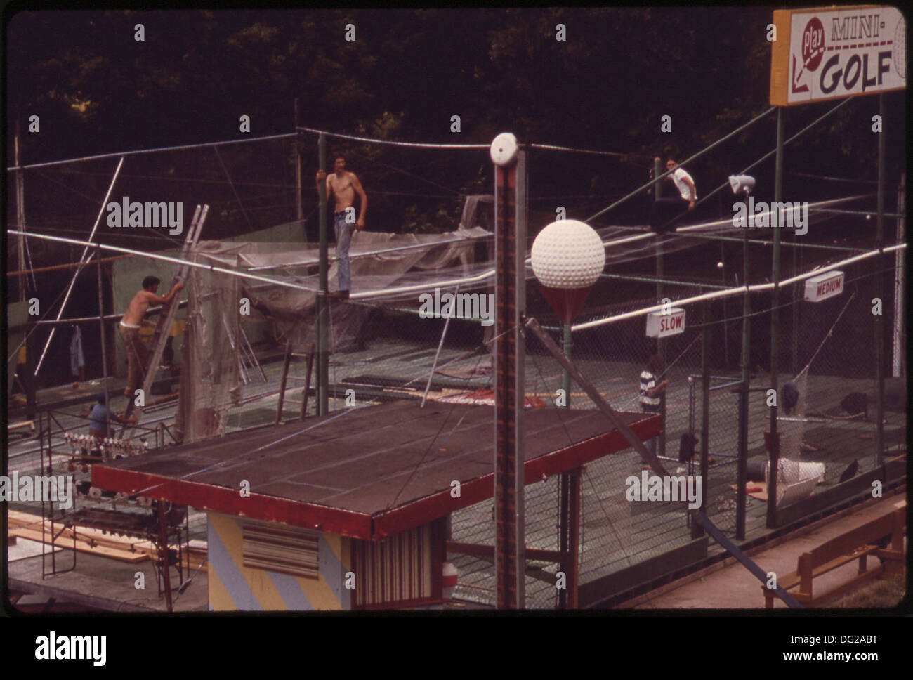 ARBEITER IN AUFMACHUNGEN NETTING AM MINIGOLF KONZESSION NAHE BAGNELL VERDAMMUNG. KONZESSION IST TEIL DES STREIFENS, EINE KILOMETERLANGE... 551289 Stockfoto