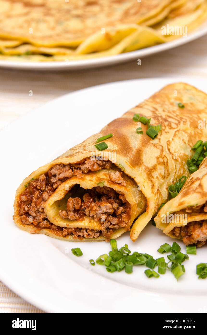 Pfannkuchen mit Füllung aus Hackfleisch und Schnittlauch in Hochformat Stockfoto