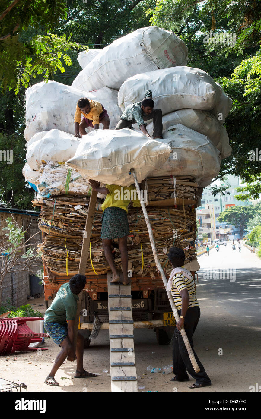 Indische Männer Überlastung einen LKW mit Hausmüll Recycling. Andhra Pradesh, Indien Stockfoto