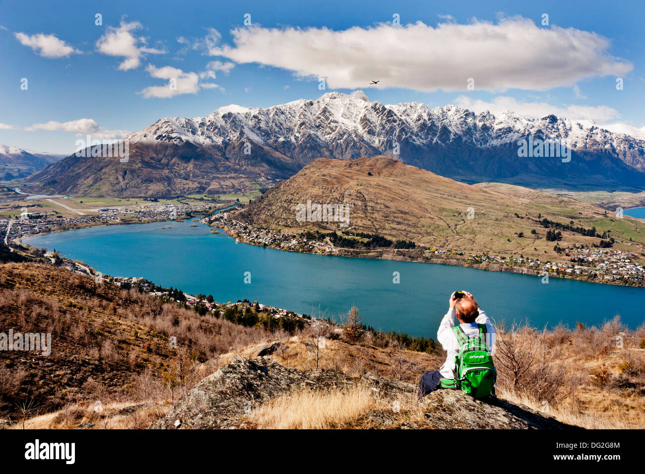 Queenstown, Südinsel, Neuseeland. Ein Fotograf der Fänge ein Flugzeug vom Flughafen Queenstown, Lake Wakatipu unten. Stockfoto