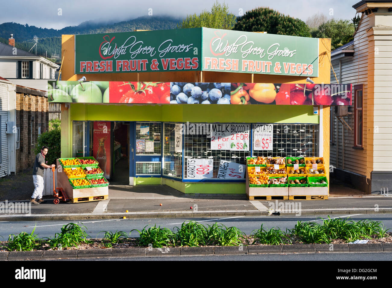 Waihi, North Island, Neuseeland. Lebensmittelhändler öffnet seinen Store in den frühen Morgenstunden und verschüttete Flüssigkeiten Obst auf dem Bürgersteig in der kleinen Goldgräberstadt. Stockfoto