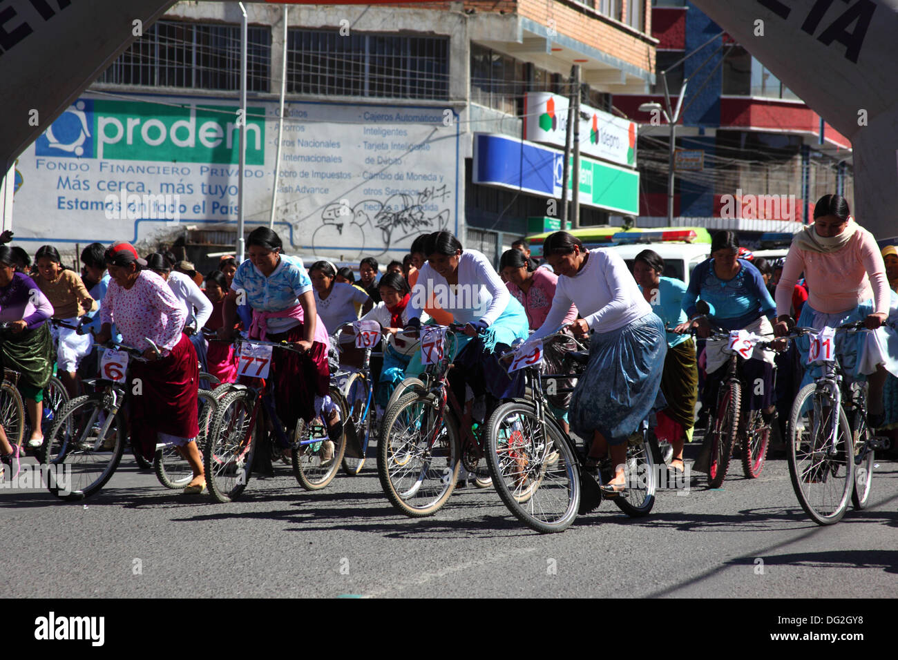 El Alto, Bolivien. Oktober 2013. Die Teilnehmer starten ein Cholitas-Fahrradrennen für indigene Aymara-Frauen. Das Rennen findet auf einer Höhe von etwas mehr als 4.000 m entlang der Hauptstraßen in El Alto (oberhalb von La Paz) zum bolivianischen Frauentag statt, der gestern Freitag, den 11. Oktober war. Quelle: James Brunker / Alamy Live News Stockfoto