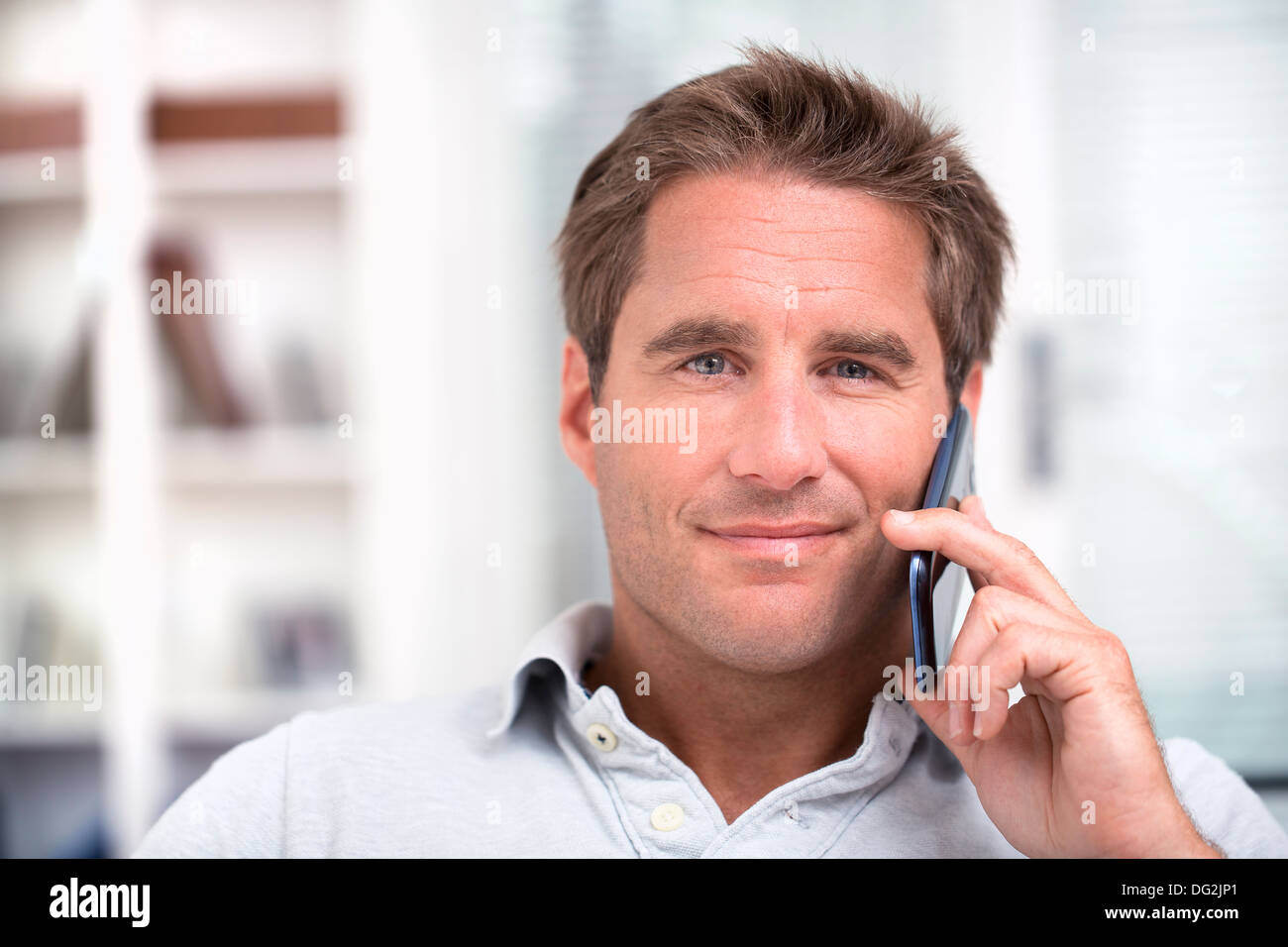 Glücklich Reifen männlichen telefonieren mit Handy indoor Stockfoto