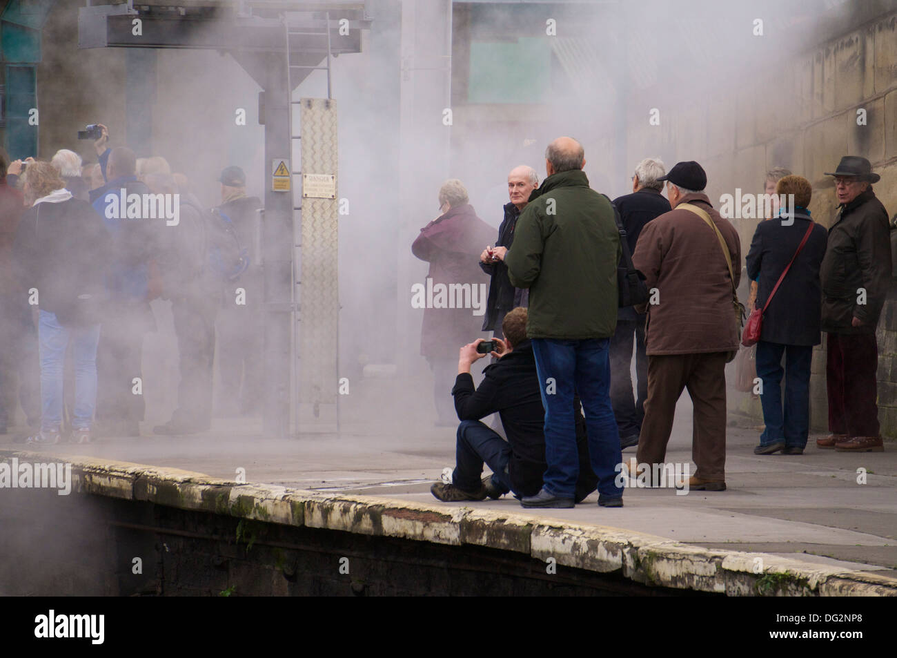 Dampf-Bahn-Enthusiasten fotografieren eingehüllt in Dampf bei Carlisle Railway Station, Cumbria. Stockfoto