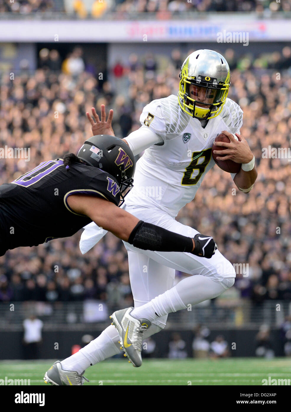 Seattle, USA. 12. Oktober 2013. Oregon Ducks Quarterback Marcus Mariota #8 abgebaut wird durch Washington Huskies Linebacker Johannes Timu #10 Husky Stadium in Seattle, WA. Oregon Niederlagen Washington 45 - 24.com George Holland / Cal Sport Media. Stockfoto