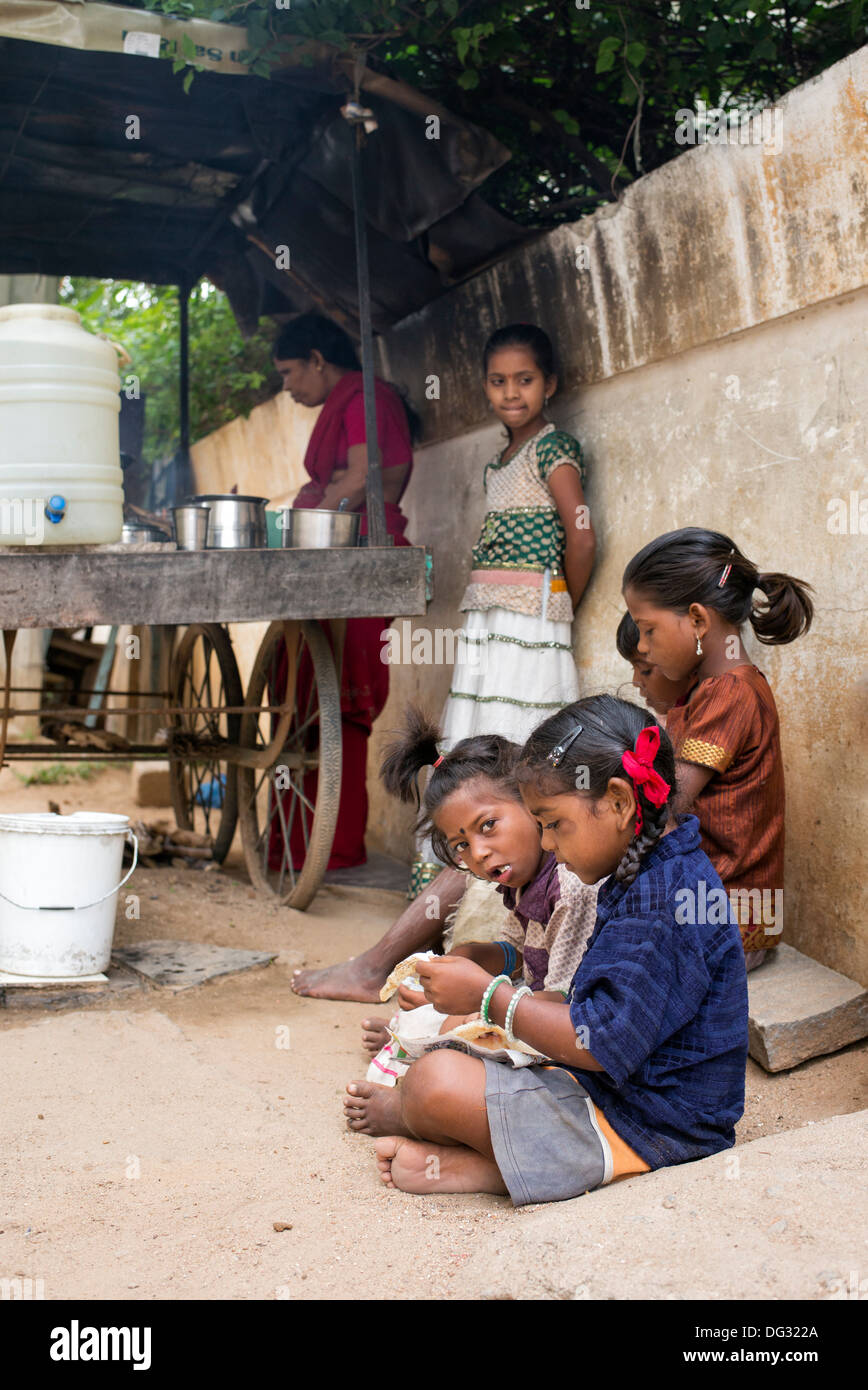 Indische niedrigere Kaste Kinder essen Dosa zum Frühstück auf einer indischen Straße. Andhra Pradesh, Indien Stockfoto