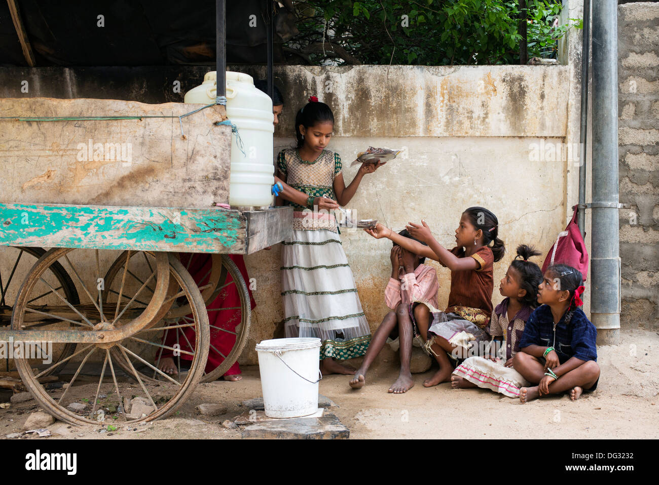 Indische niedrigere Kaste Kinder essen Dosa zum Frühstück aus einer indischen Straße Nahrung Warenkorb. Andhra Pradesh, Indien Stockfoto
