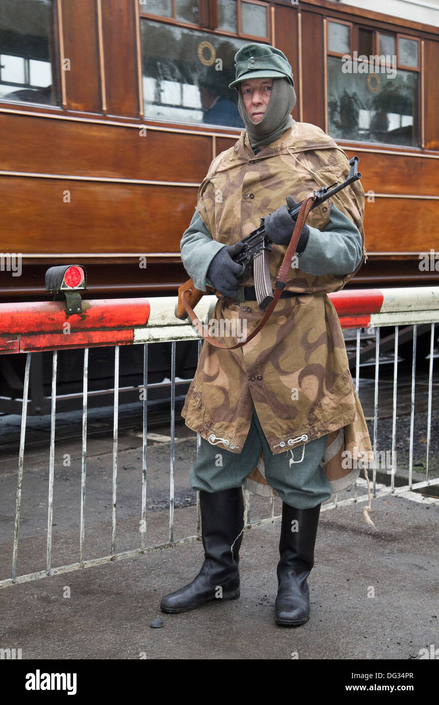 Weltkrieg, Zweiter Weltkrieg, Weltkrieg, WW2; Levisham. North Yorkshire, UK. 11. Oktober, 2013. Bob Fleming mit einem deutschen Soldaten bewacht die Bahn holidng ein MG34 machine gun auf die "Eisenbahn in Kriegszeiten "North Yorks Moors Railway (NYMR) Fall an Levisham Bahnhof. Levisham, war mit Postern dekoriert, und Französisch während der Kriegszeit (NYMR) 'Wochenende'' Le Visham zu werden' im Norden Frankreichs. Die Sammlung, die Erholung von einem französischen Dorf, das von deutschen Truppen besetzt, die Teil der "Allo Allo" - style unbeschwerte und lustige Stimmung. Stockfoto