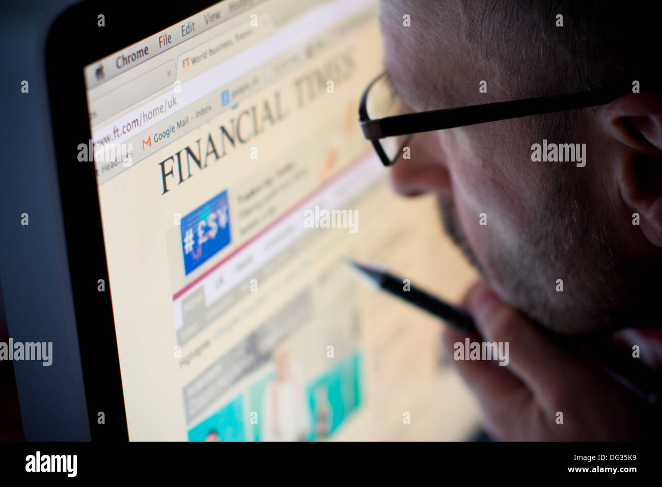 Männlicher Erwachsener, der auf einem Computerbildschirm auf der Website der Financial Times surft und die Interaktion mit globalen Geschäfts- und Finanznachrichtenmedien in Großbritannien über digitale Online-Plattformen veranschaulicht Stockfoto