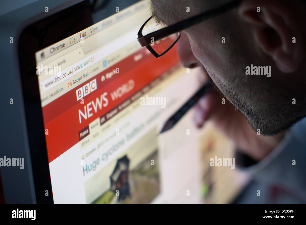 Erwachsene männliche Blick auf die Online-Internet-Website der bbc-news Stockfoto