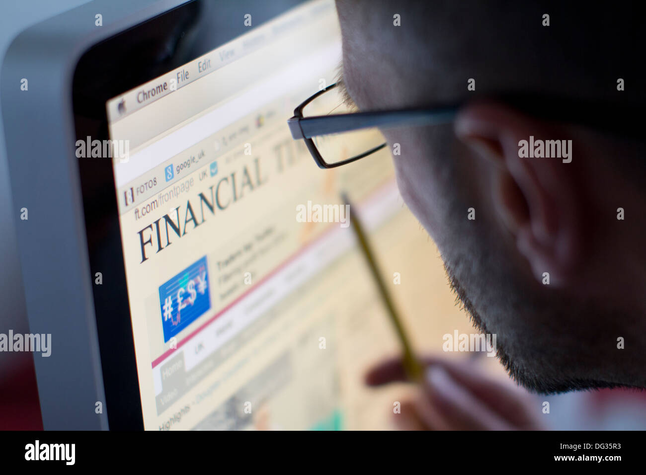 Männlicher Erwachsener, der auf einem Computerbildschirm auf der Website der Financial Times surft und die Interaktion mit globalen Geschäfts- und Finanznachrichtenmedien in Großbritannien über digitale Online-Plattformen veranschaulicht Stockfoto