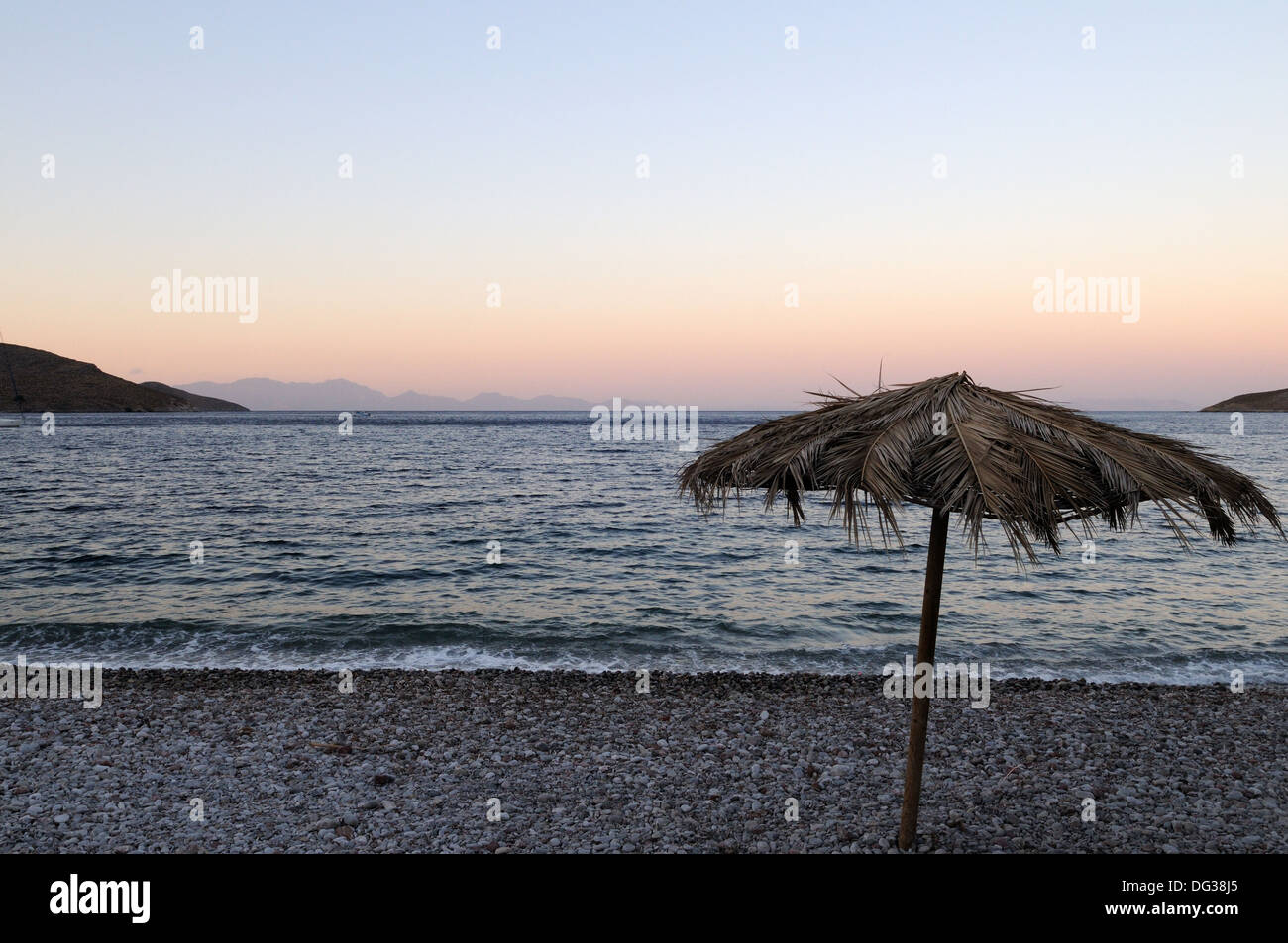 Sonnenschirm, hergestellt aus hinterlässt auf Livadia Strand Tilos in der Abenddämmerung die Dodekanes-Griechenland Stockfoto