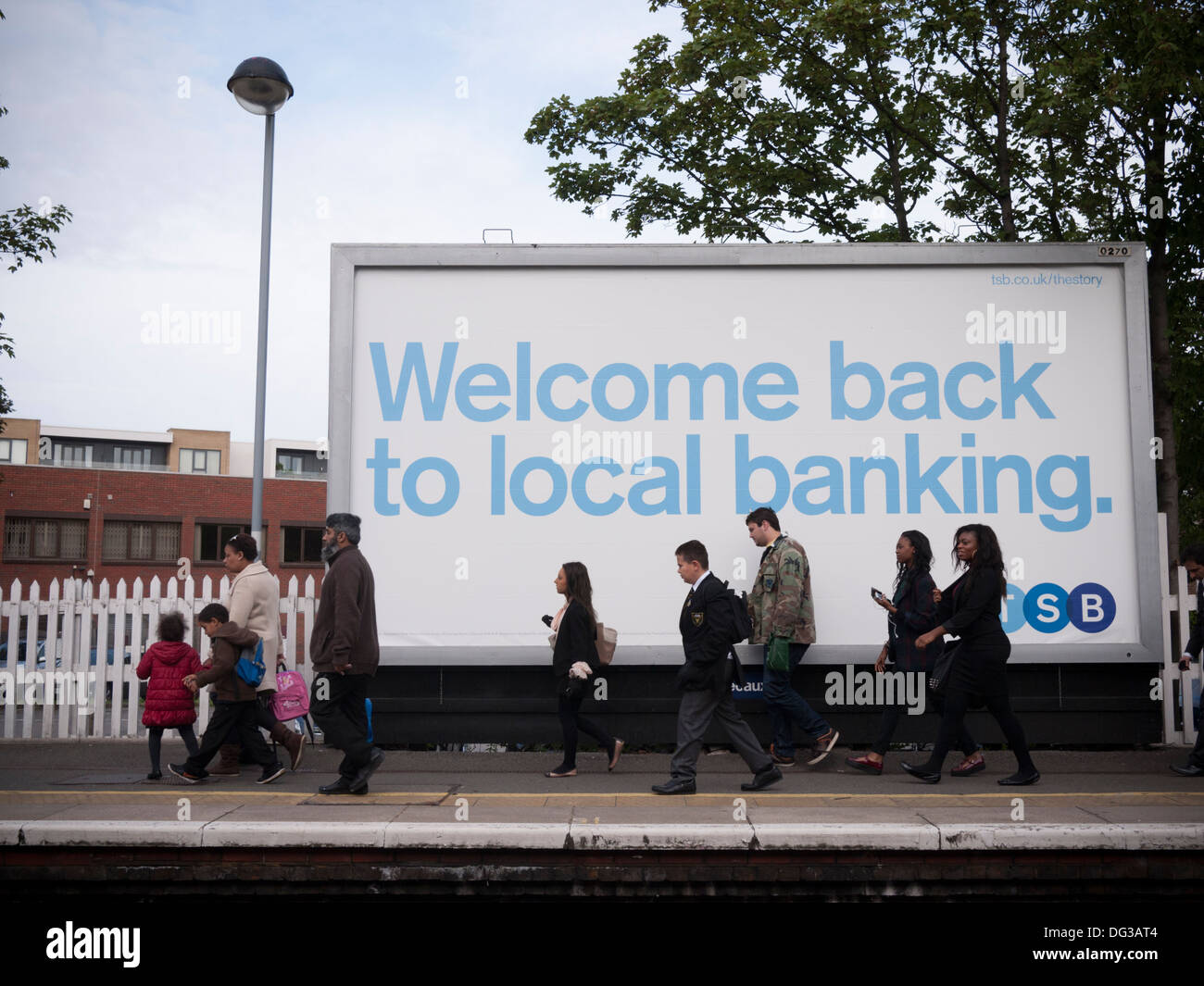 Pendler gehen an einer Trustee Savings Bank (TSB) vorbei, die auf einem Poster an einem Londoner Bahnhof, Großbritannien, „Welcome Back to Local Banking“ (Willkommen beim lokalen Bankgeschäft) stand. Stockfoto