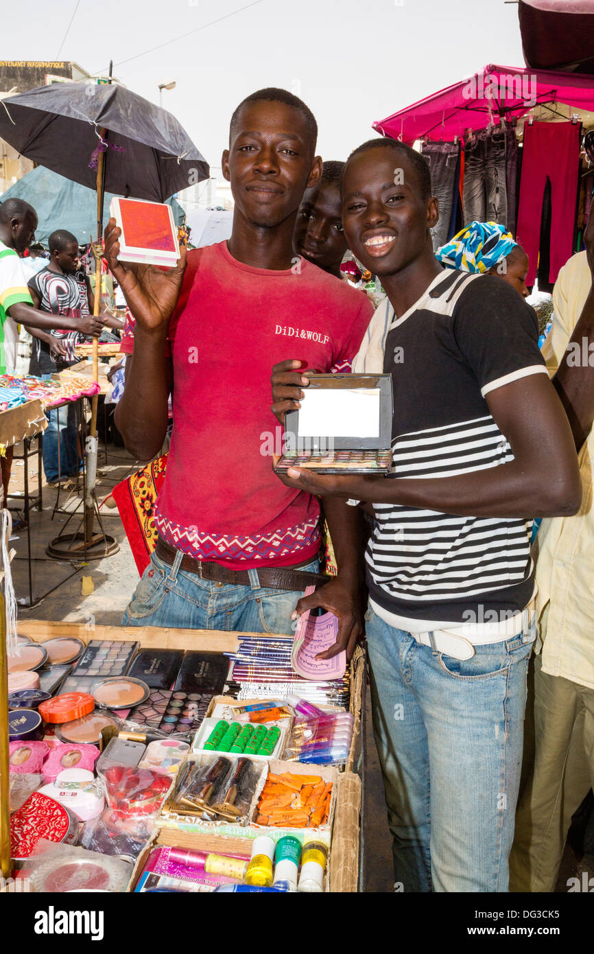 Senegal, Touba. Junge Männer zeigen ihre waren auf dem Markt. Stockfoto