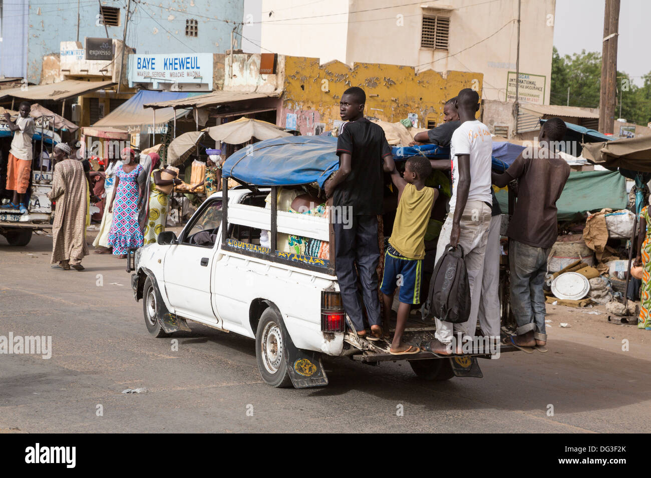 Senegal, Touba. Den Nahverkehr. Pick-ups mit jungen Männer in der Regel hängen auf dem wieder Trittbrett, Passagiere im Inneren. Stockfoto