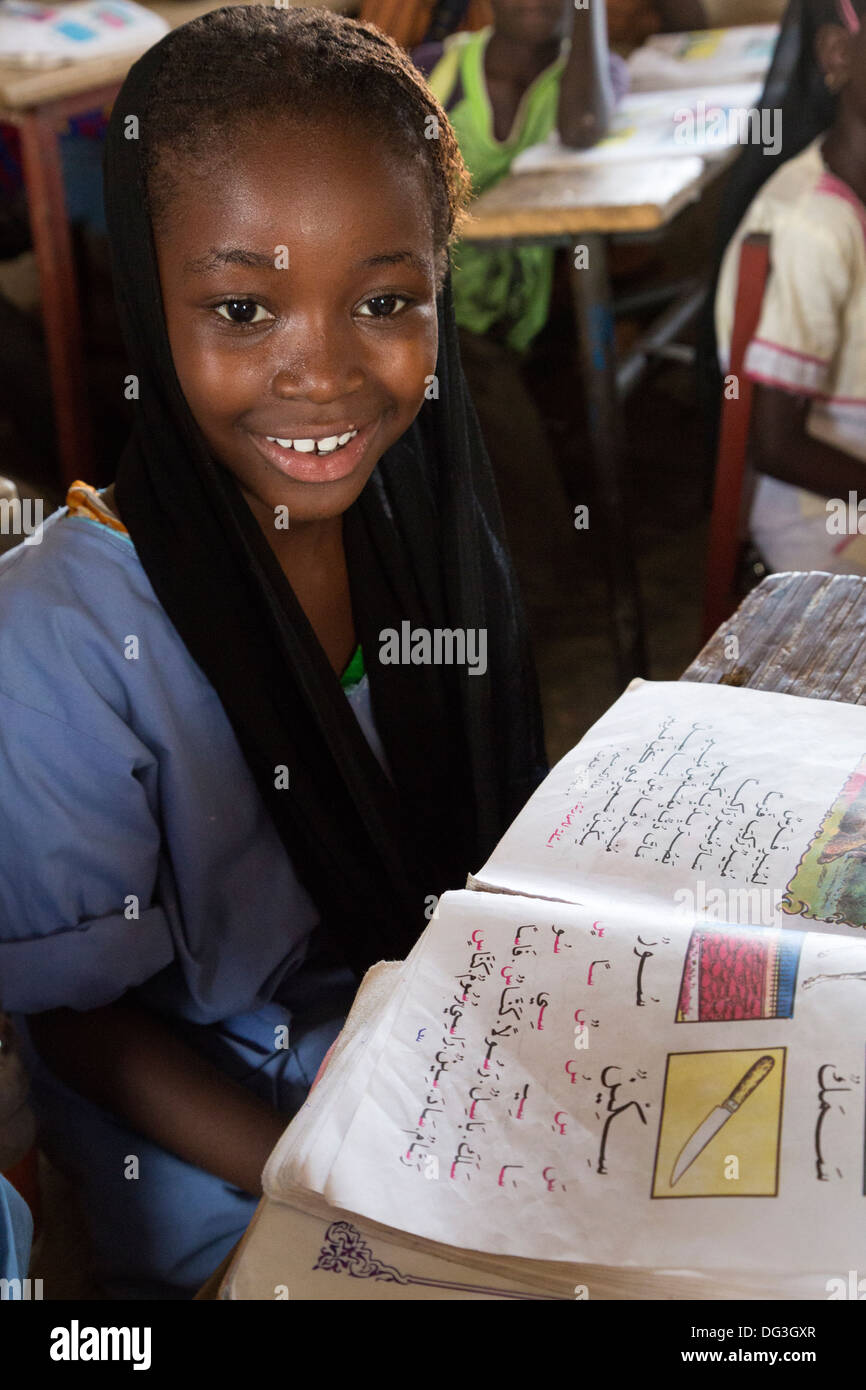 Senegal, Touba. Junges Mädchen am Al-Azhar Madrasa, eine Schule für islamische Studien. Ihr Buch zeigt, dass sie Arabisch lernen. Stockfoto