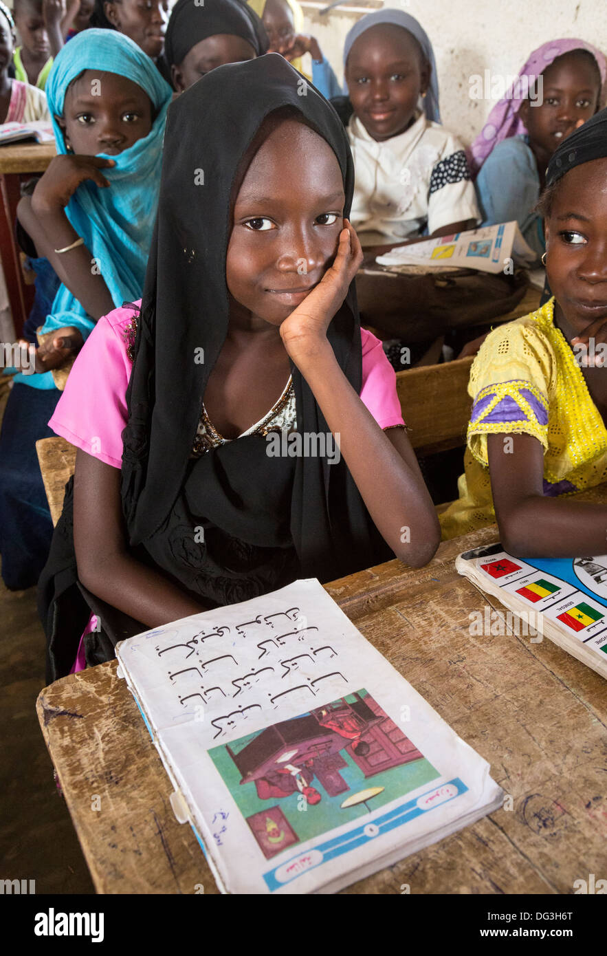 Senegal, Touba. Junges Mädchen mit ihrem Arabisch-Reader auf der Madrasa Al-Azhar, eine Schule für islamische Studien. Stockfoto