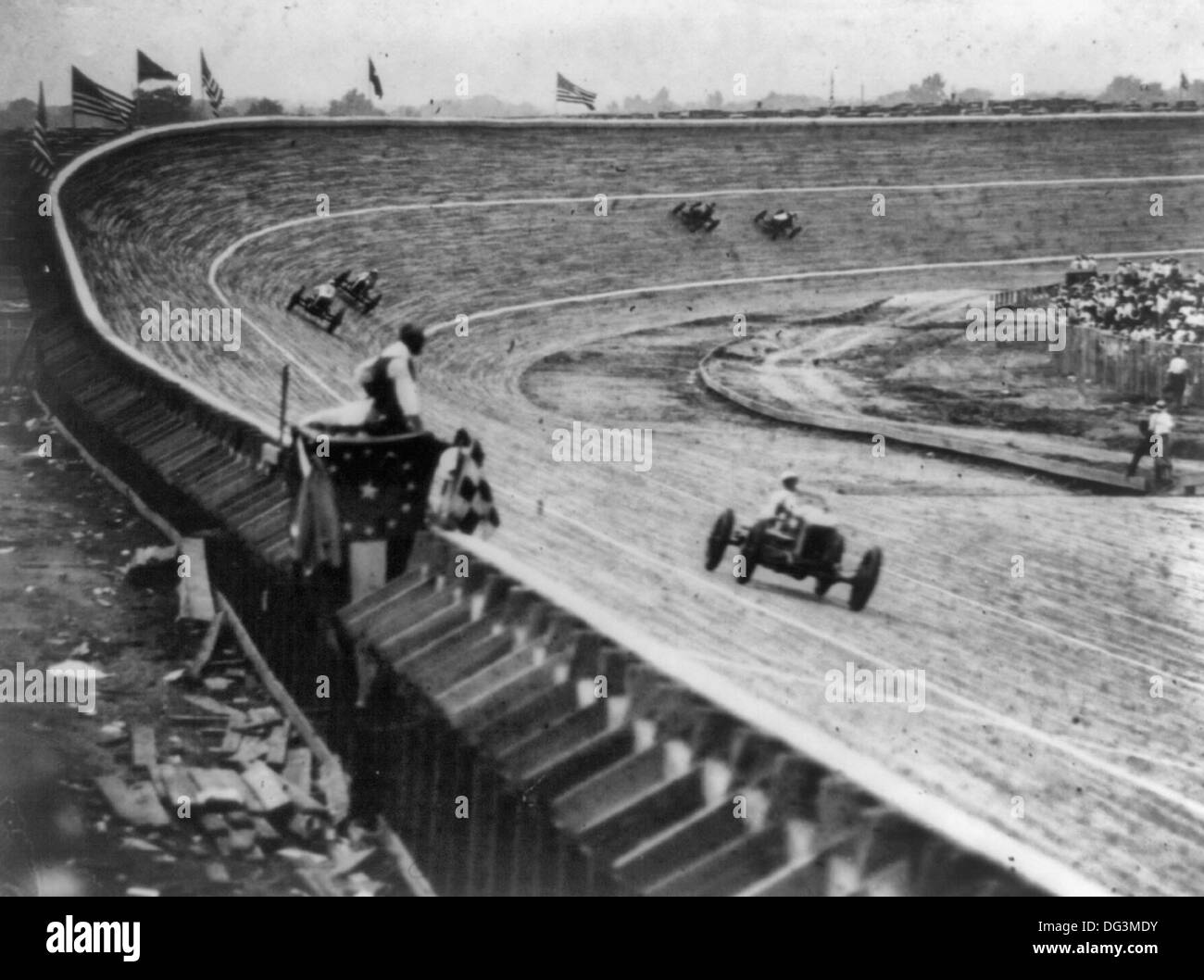 Automobil-Rennsport auf gekrümmten Holz Weg, wahrscheinlich in oder in der Nähe von Washington, D.C., mit Flagge Mann im Vordergrund, ca. 1922 Stockfoto