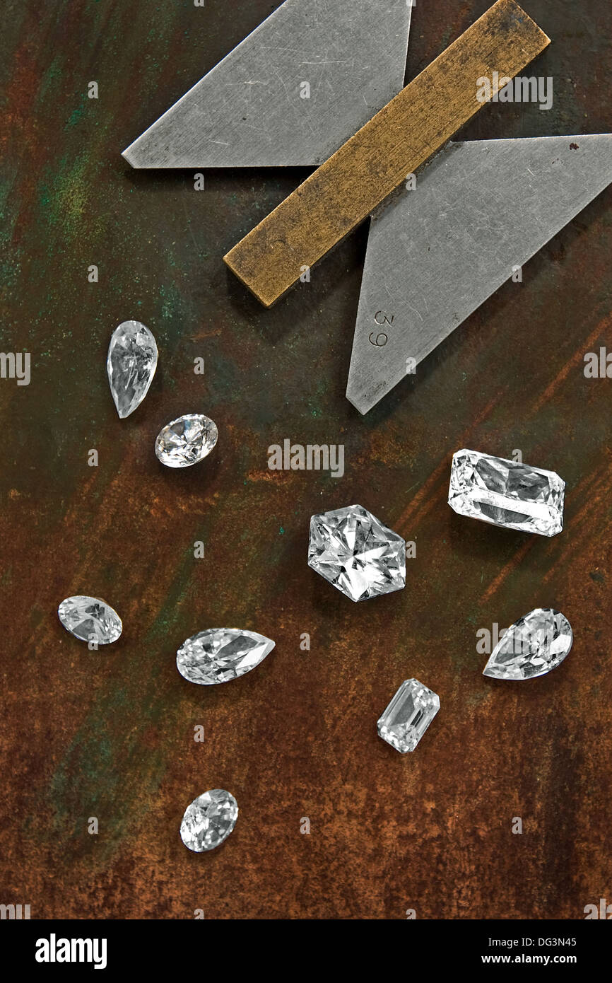 einige Diamanten über Leder Hintergrund und Manometer Stockfoto