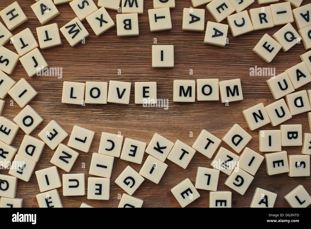 Plastische Buchstaben aus einem Kinder Rechtschreibung Spiel auf einem Holztisch buchstabieren "I Love Mom" Stockfoto