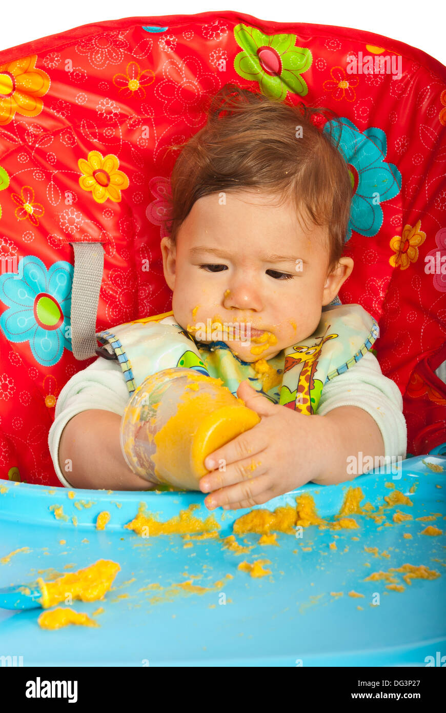 Chaotisch Babyjungen Püree selbst Essen und sitzen auf Stuhl Stockfoto