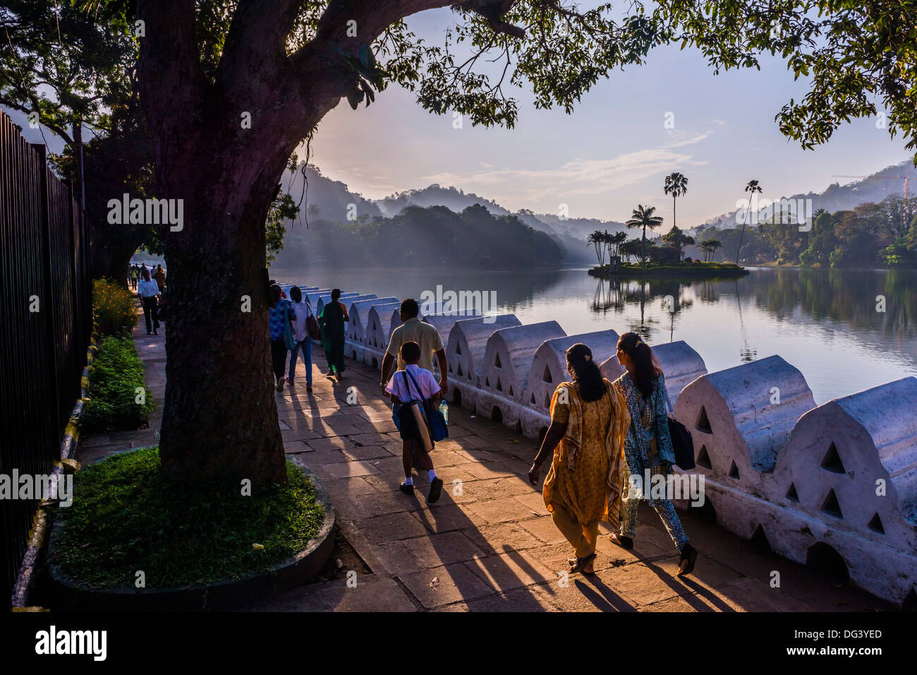 Bevölkerung Sri Lankas zu Fuß in Kandy Lake bei Sonnenaufgang, Kandy, Central Province, Sri Lanka, Asien Stockfoto