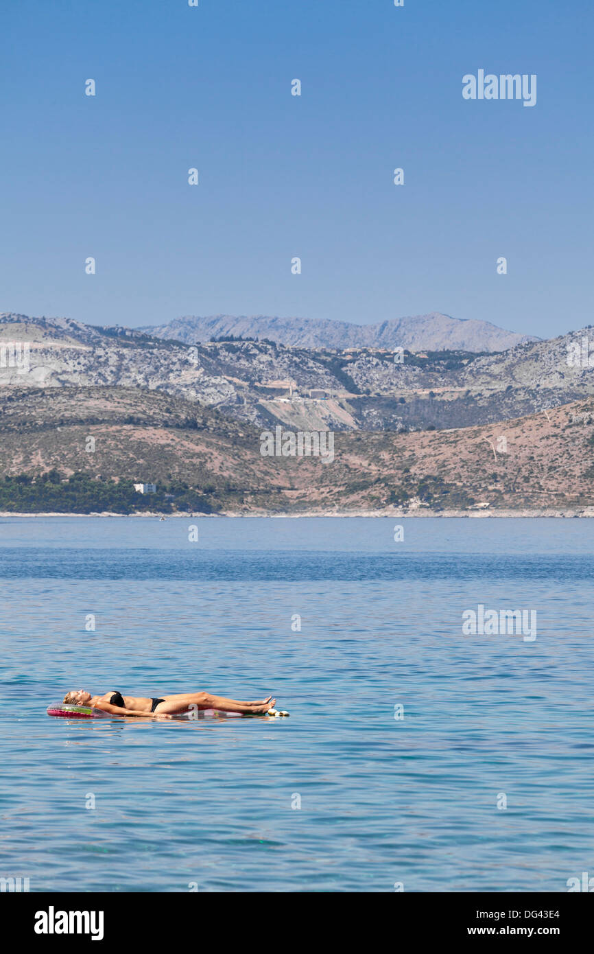 Eine Frau Sonnenbaden an einem Lilo, Dubrovnik, Dalmatien, Kroatien, Europa Stockfoto