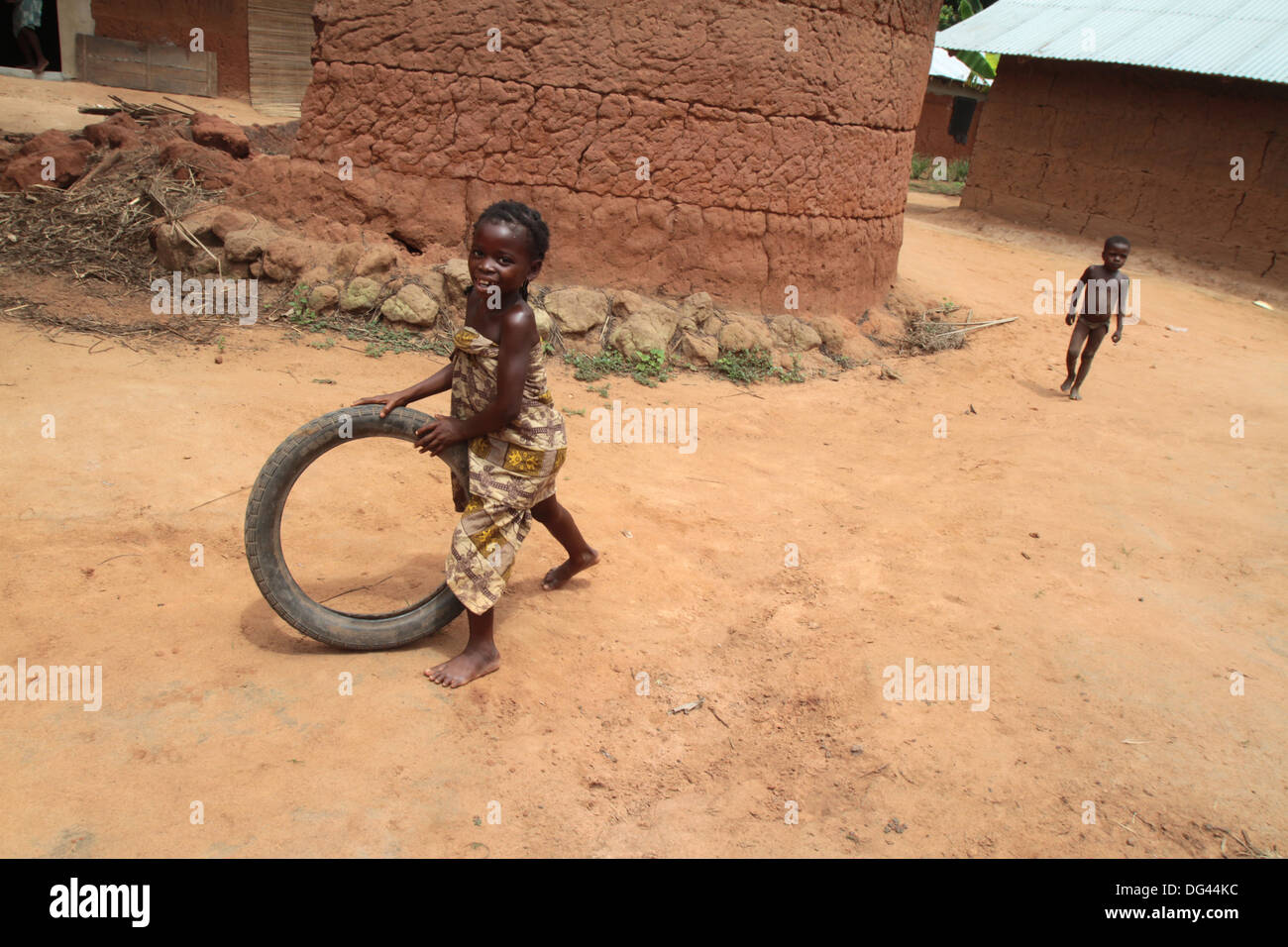 Afrikanische Mädchen Spaß Rollen einen alten Reifen, Tori, Benin, Westafrika, Afrika Stockfoto