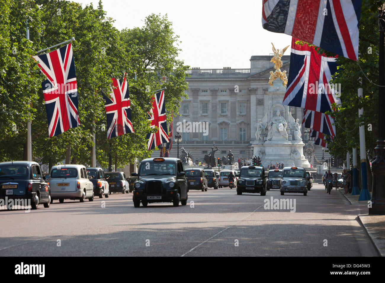 Buckingham Palace mit Taxis und Union Jacks entlang der Mall, London, England, Vereinigtes Königreich, Europa Stockfoto