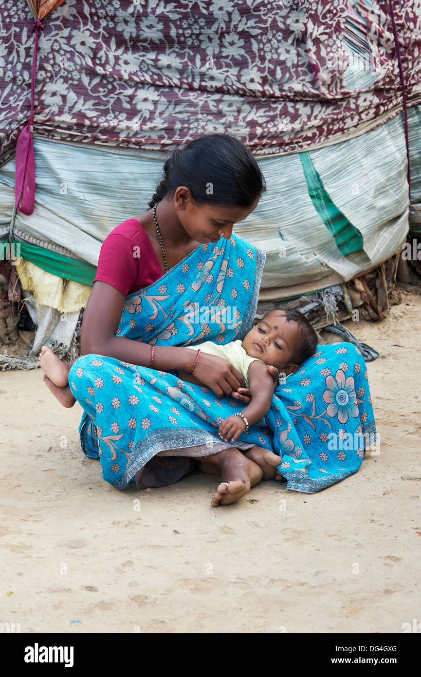 Junge niedrigere Kaste Inderin mit ihrem Baby draußen ihr Bender / Zelt / shelter. Andhra Pradesh, Indien Stockfoto