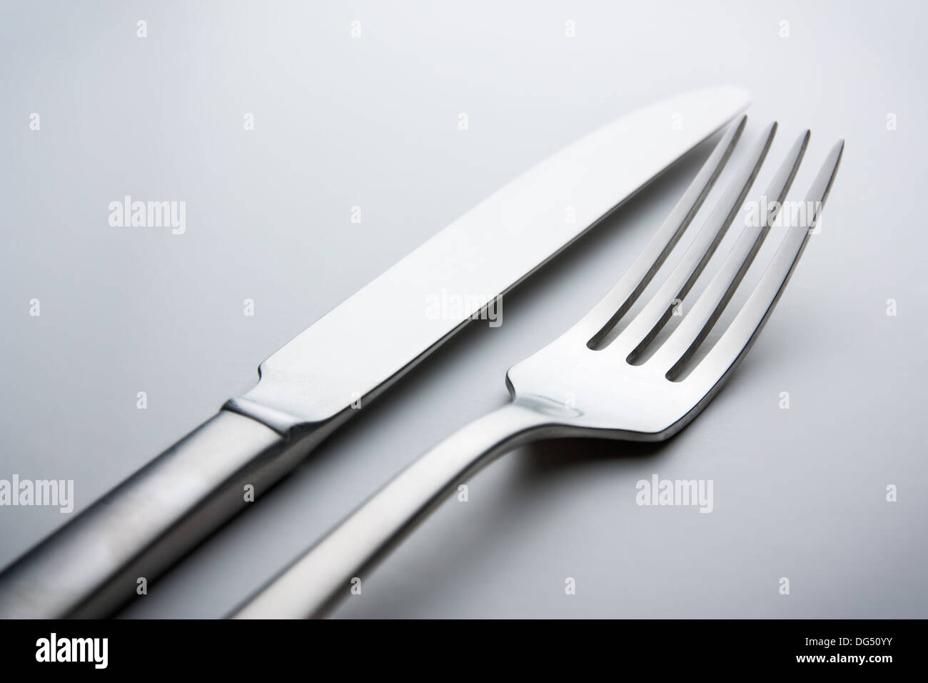 Silber Messer und Gabel auf neutralem Hintergrund Stockfoto