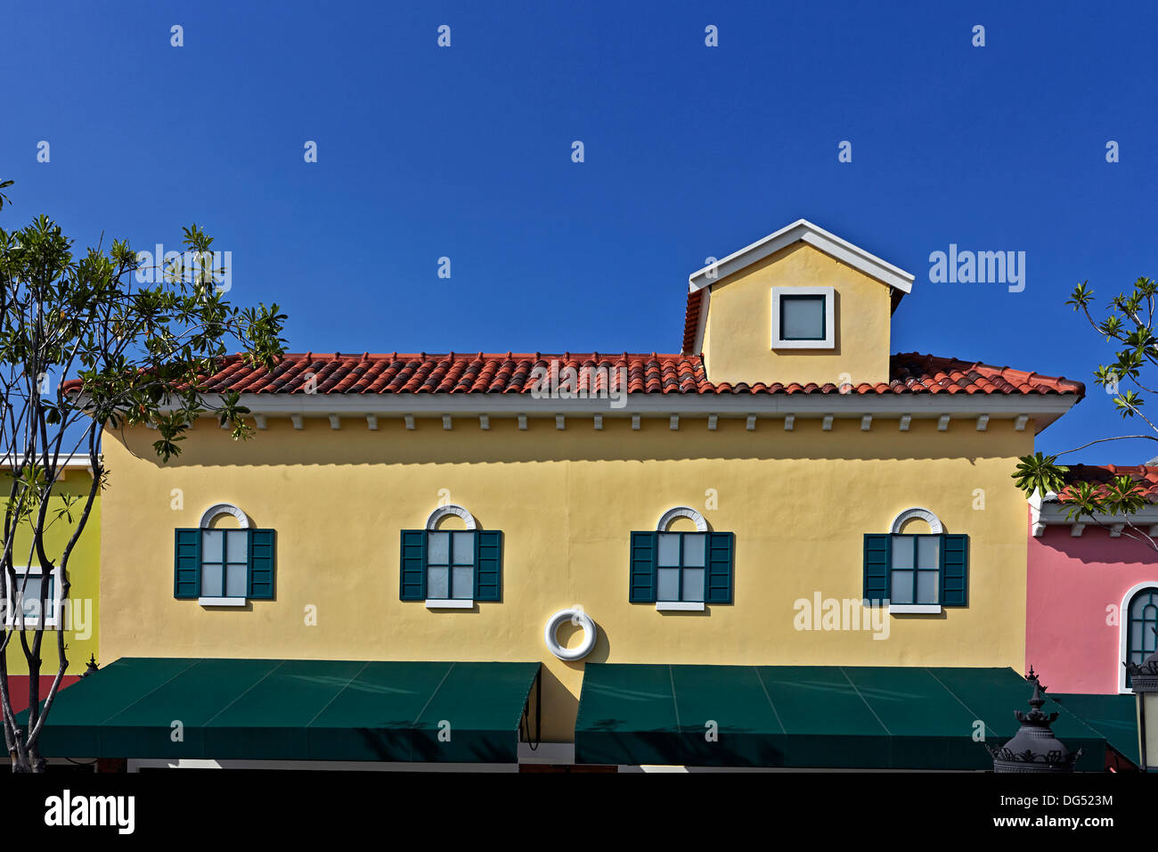 Farbenfrohe Gebäude gemalt hell lebhaft gelb gegen tiefblauen Sommerhimmel. Stockfoto