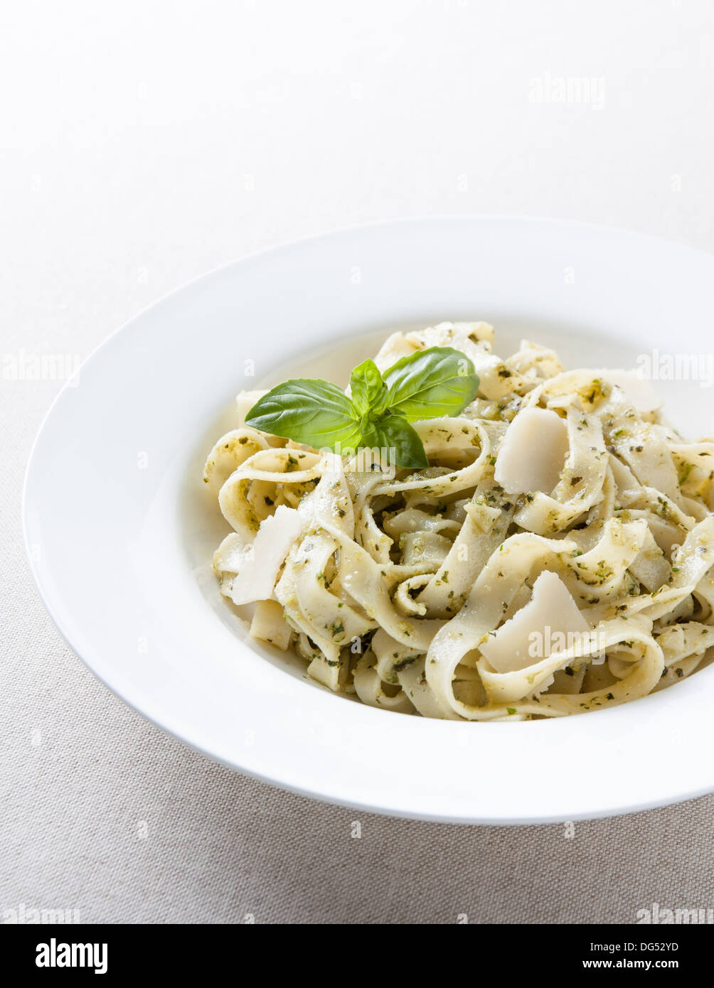 Teller mit Fettuccine al Pesto mit Basilikum Blätter Stockfoto