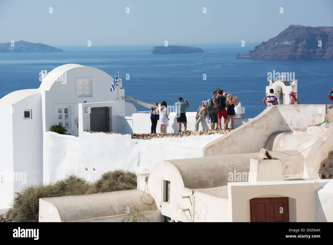 SANTORINI (THIRA), KYKLADEN, GRIECHENLAND. Urlauber zu bewundern und zu fotografieren, die Aussicht von den Klippen Dorf Oia. 2013. Stockfoto