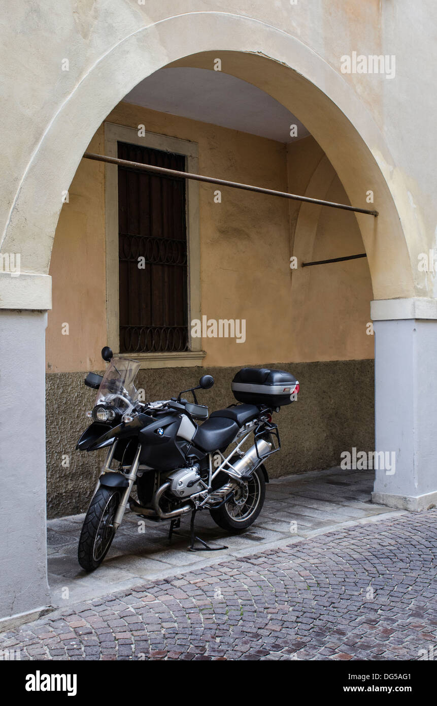 Schwarzen BMW touring Motorrad geparkt auf eine leere saubere Straße in Italien geschützt unter einem Bogen. Stockfoto