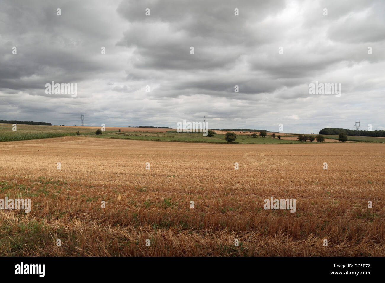 Dunkle Wolken über einem kürzlich geernteten Weizenfeld in Nordfrankreich. Stockfoto
