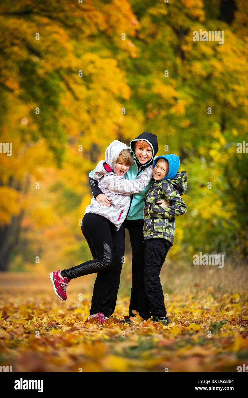 Mutter mit Kindern im Park spielen im Herbst Stockfoto
