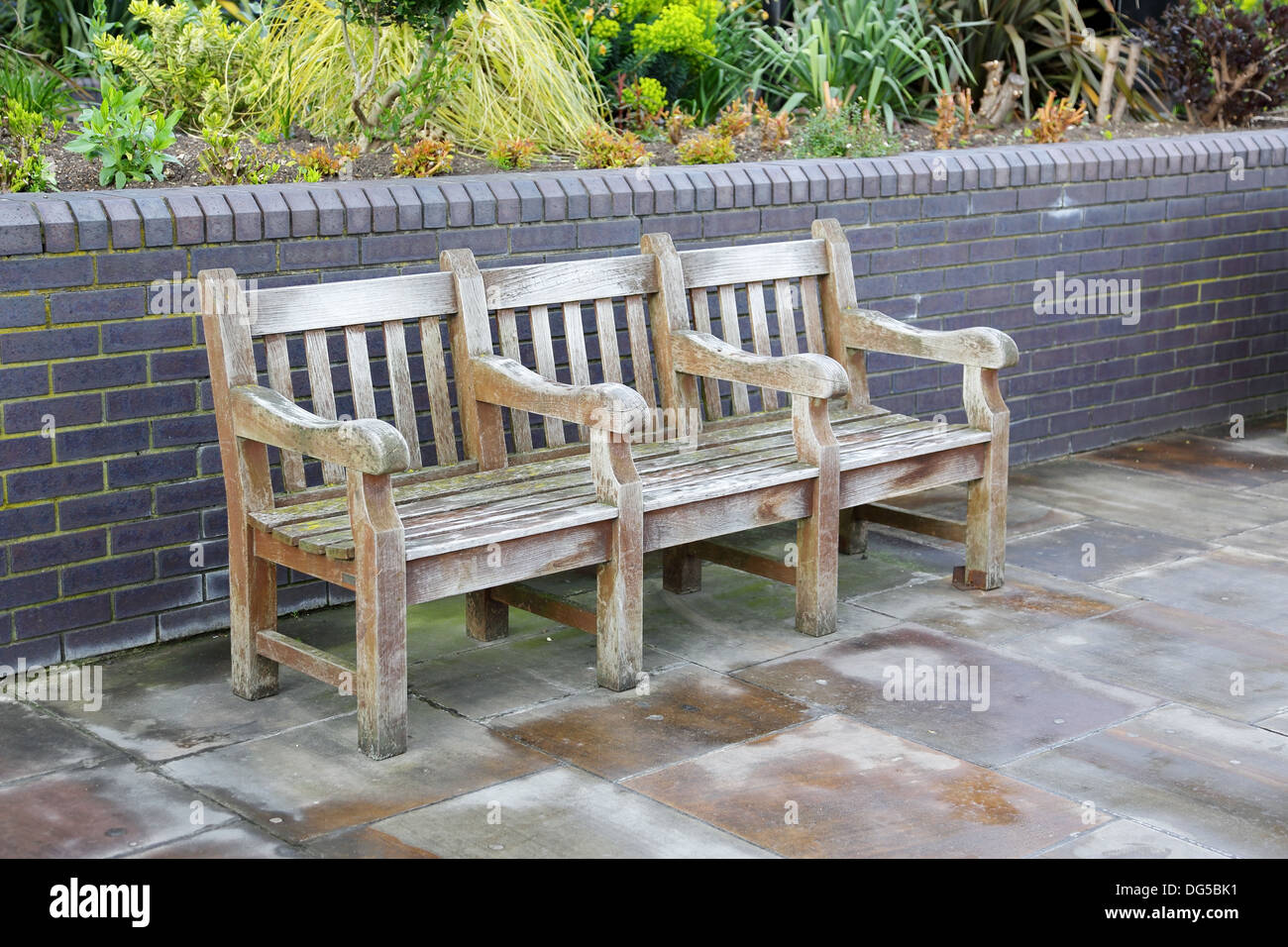 Holzbank mit Arm ruht auf dem Bürgersteig Stockfoto