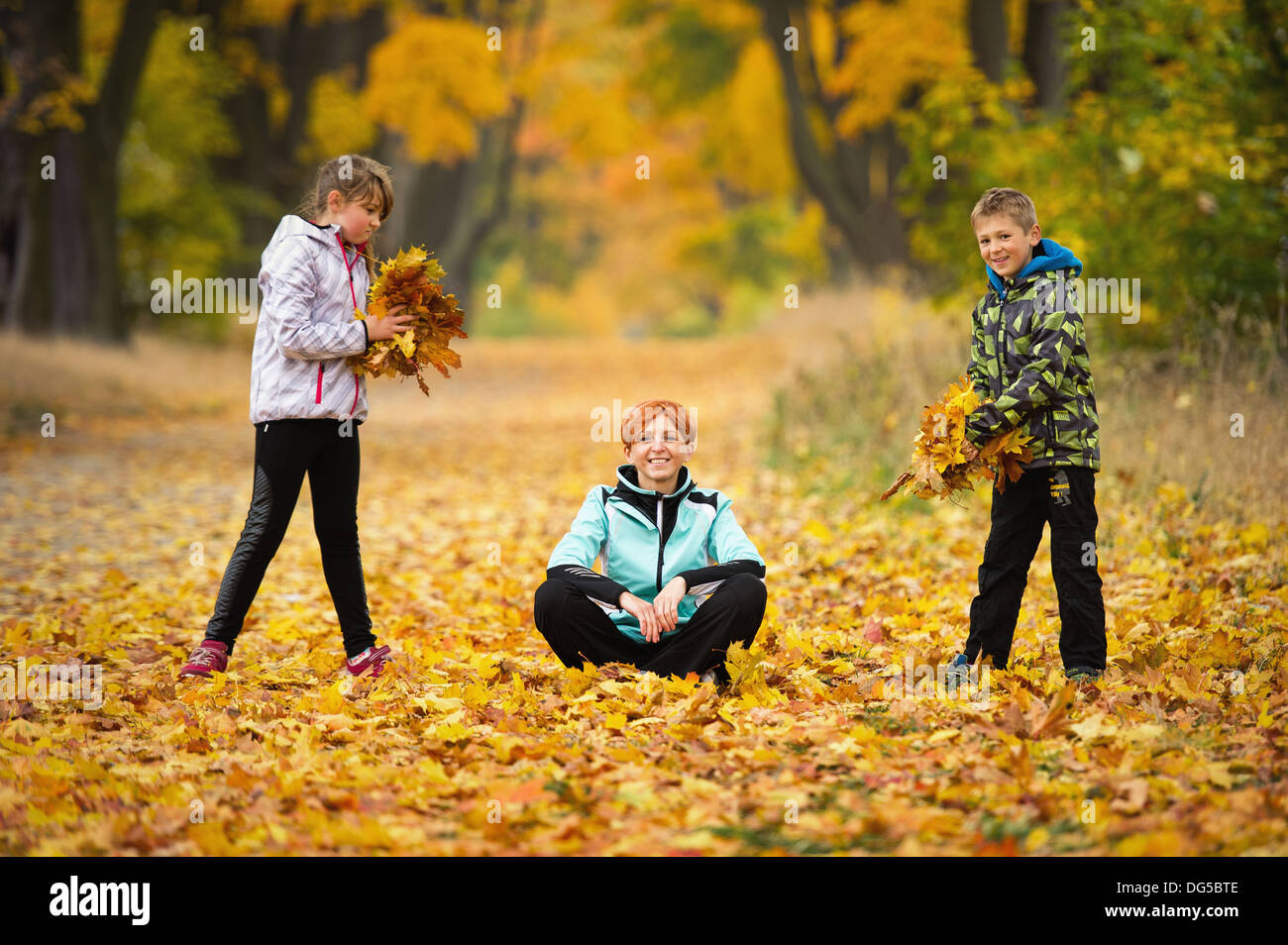 Mutter mit Kindern im Park spielen im Herbst Stockfoto