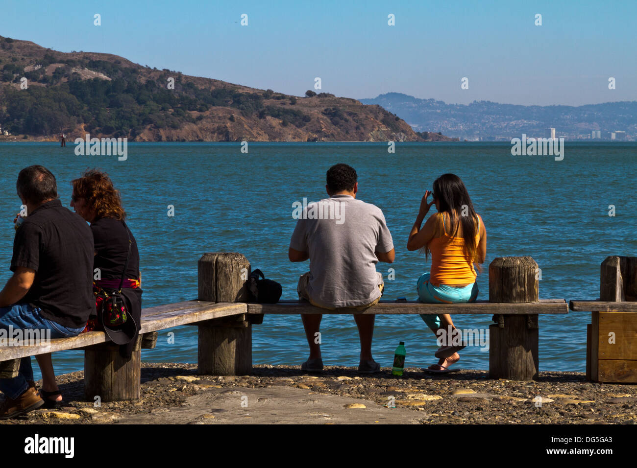 Zwei Paare sitzen auf Bank in Sausalito, Kalifornien, mit Blick auf San Francisco Bay und Angel Island. Stockfoto