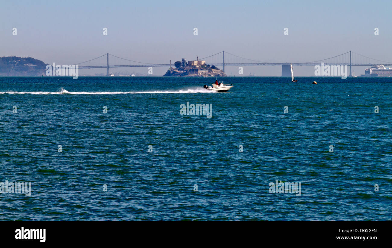 Mit dem Schnellboot am laufenden Band, eine Totenwache in der San Francisco Bay mit der Bay Bridge und Alcatraz Gefängnisinsel im Hintergrund Stockfoto