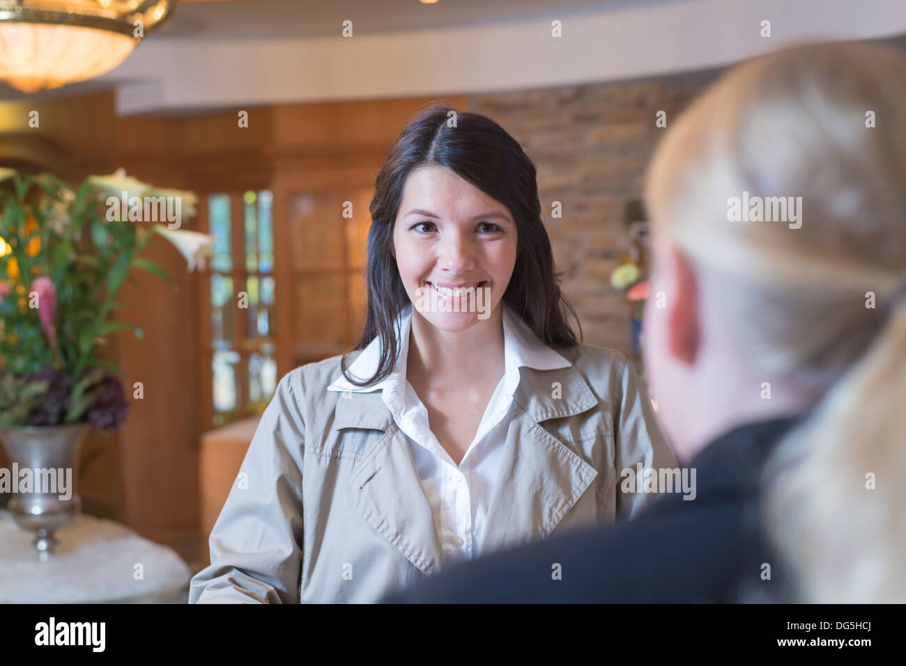 junge Frau an der Hotelrezeption Stockfoto