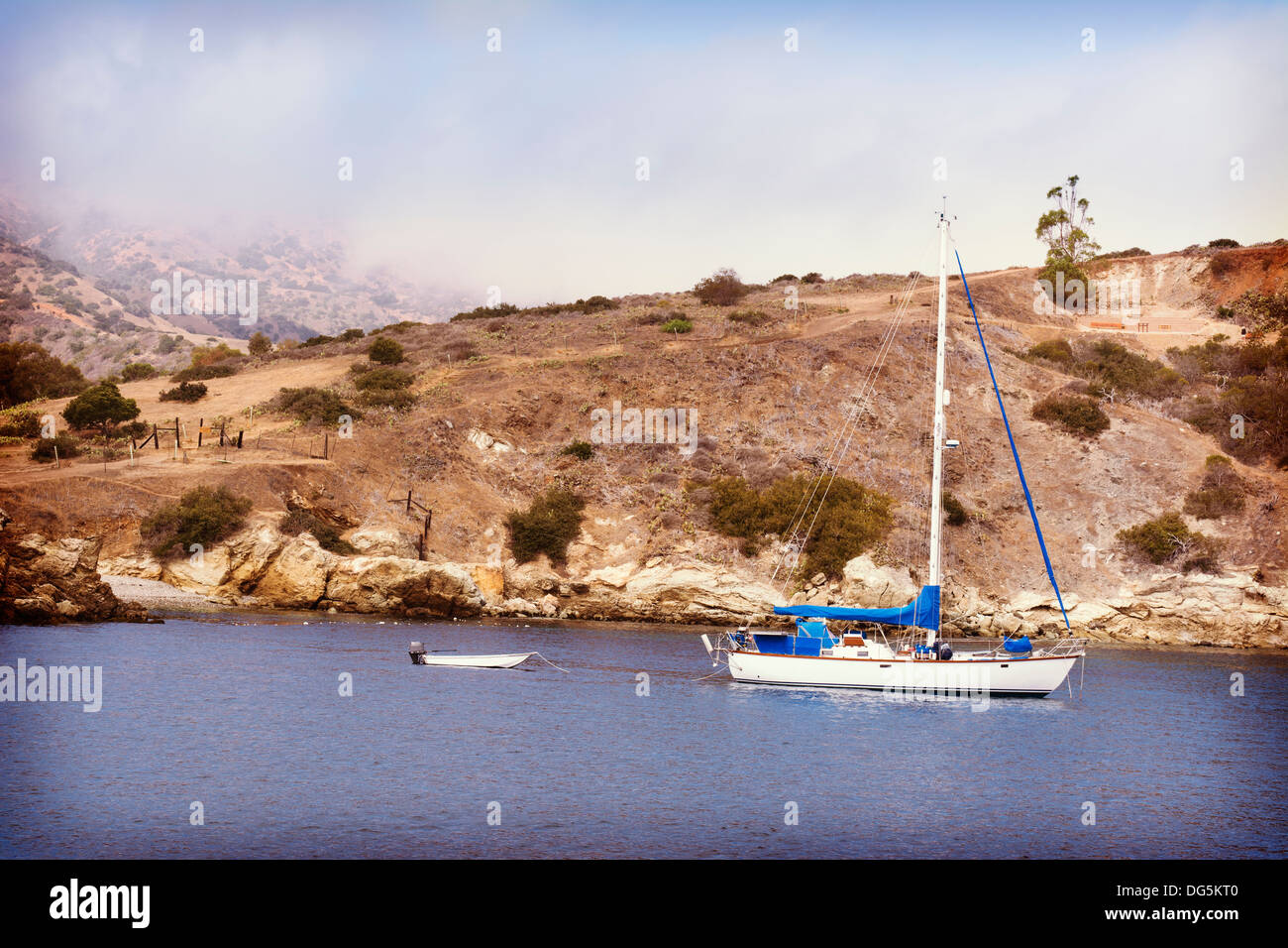 Ein Segelboot und schmuddeligen verankert in einer Bucht auf Catalina Island. Stockfoto