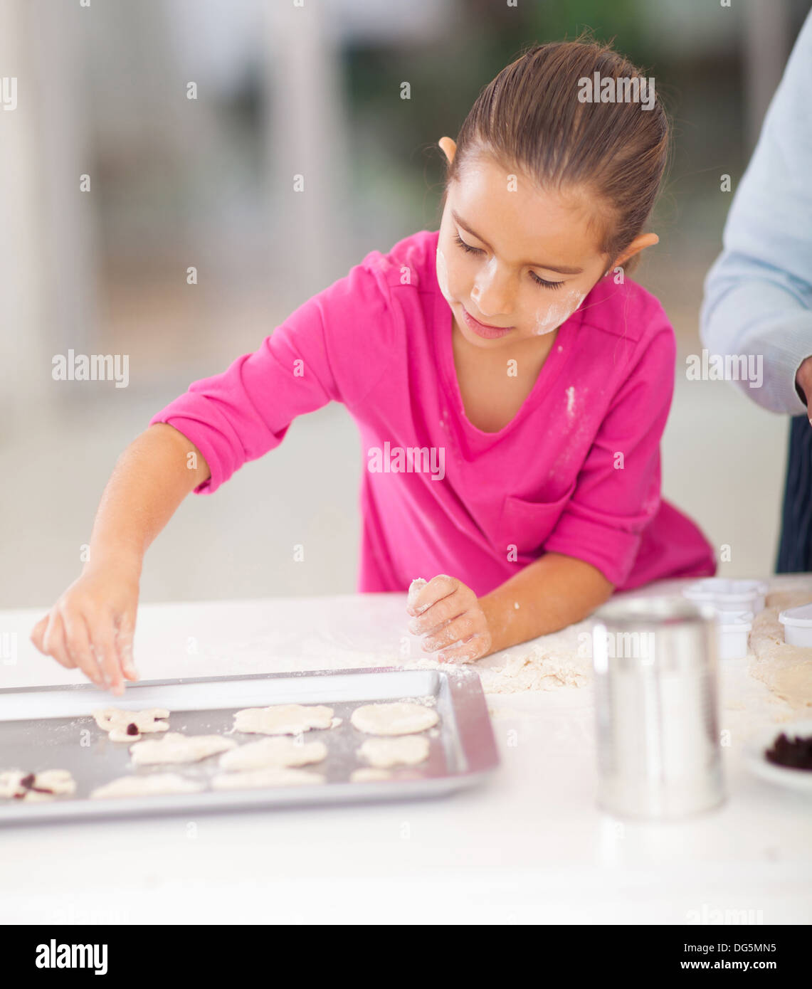 kleines Mädchen backen Kekse in Küche mit Elternteil Stockfoto