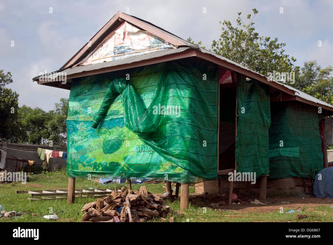 Ein Holzhaus auf Stelzen ist umhüllt von Grün in einer Nachbarschaft in Phnom Penh, Kambodscha. Stockfoto