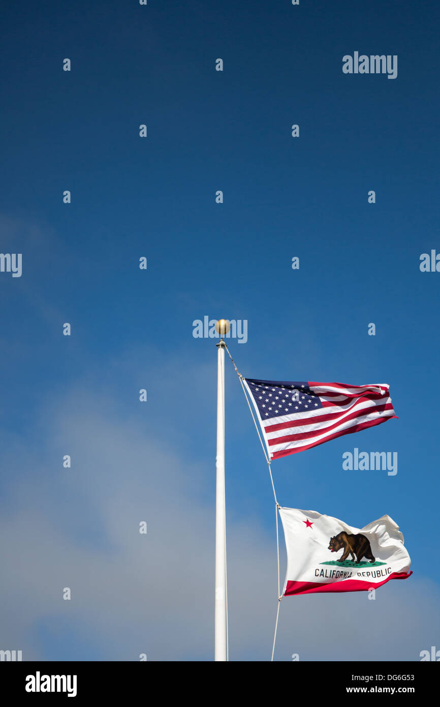 USA und California Flaggenstaat flattern im Wind vor blauem Himmel Stockfoto