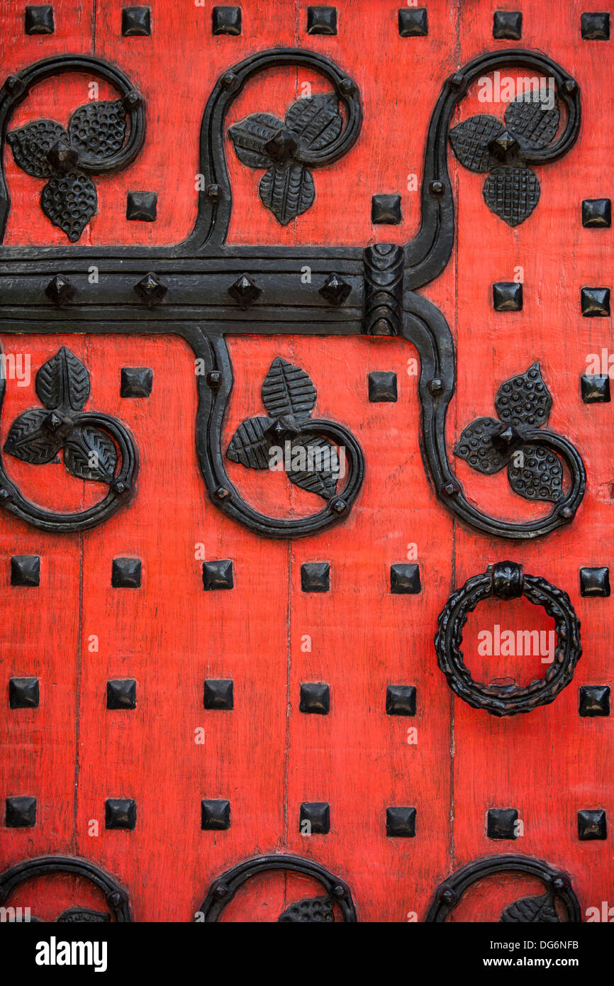 Detail von einem roten verzierte Kirchentür mit schwarzen Metall-details Stockfoto